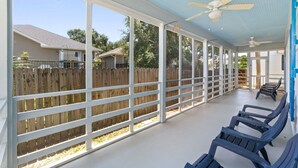 Un patio couvert avec vue sur une clôture en bois et des maisons en arrière-plan.