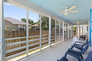 A covered patio area with a view of a wooden fence and houses in the background. - 3BR Coastal Retreat | 10 Min to Beaches (Pensacola)