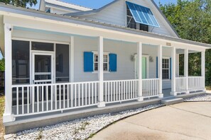A two-story house with a covered porch, white railings, and a green door. - 3BR Coastal Retreat | 10 Min to Beaches (Pensacola)