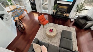 A spacious living area with a sofa, a coffee table, and a fireplace.