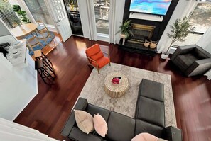 A spacious living area with a sofa, a coffee table, and a fireplace. - Daylilly House/ Family Friendly with Gameroom (Lawrenceville)