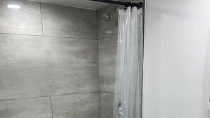 Ein Badezimmer mit Dusche, Toilette und Waschbecken.