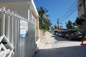 Ein verschlossenes Tor zu den Villas Princesa, mit einem Schild, das Annehmlichkeiten wie Instandhaltung, Warmwasser, Sicherheit und Internet auflistet.