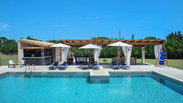 A pool area with lounge chairs, umbrellas, and a bar. - Impressive & Spacious Villa - Private Pool, Outdoor Kitchen, Bar & Sauna - 20 mis walk to Alcudia! (Alcudia)