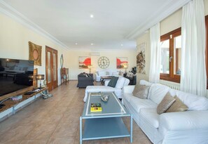 Ein Wohnzimmer mit Fernseher, Sofa, Couchtisch und Kunstwerken.