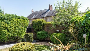 A residential property with a brick wall, a well-maintained garden, and a house with a grey roof. - Modern Home nr Exeter, Garden & Private Parking (Bradninch)
