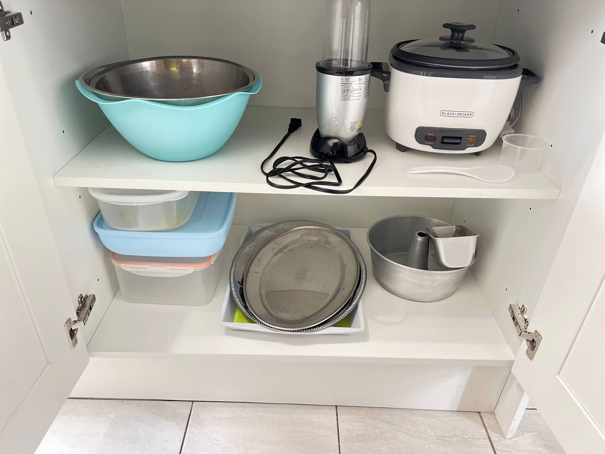 A kitchen with a blender, a slow cooker, a mixing bowl, and storage containers.