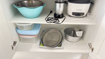 A kitchen with a blender, a slow cooker, a mixing bowl, and storage containers.