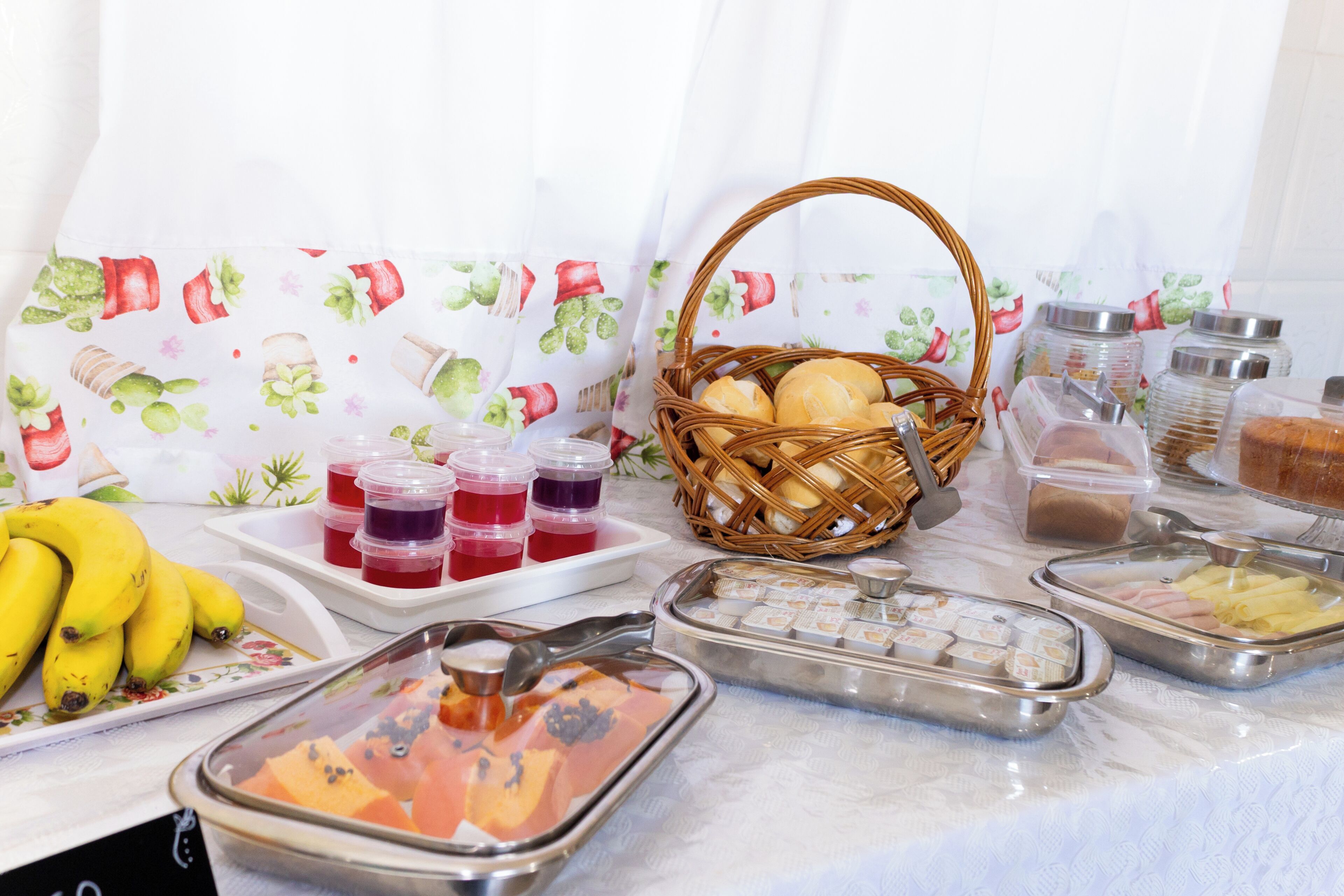 A buffet setup with various food items, including fruits, bread, and condiments.