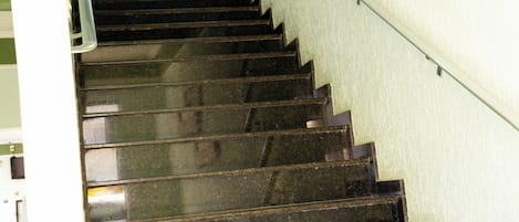 A staircase with a handrail and a sign prohibiting smoking.