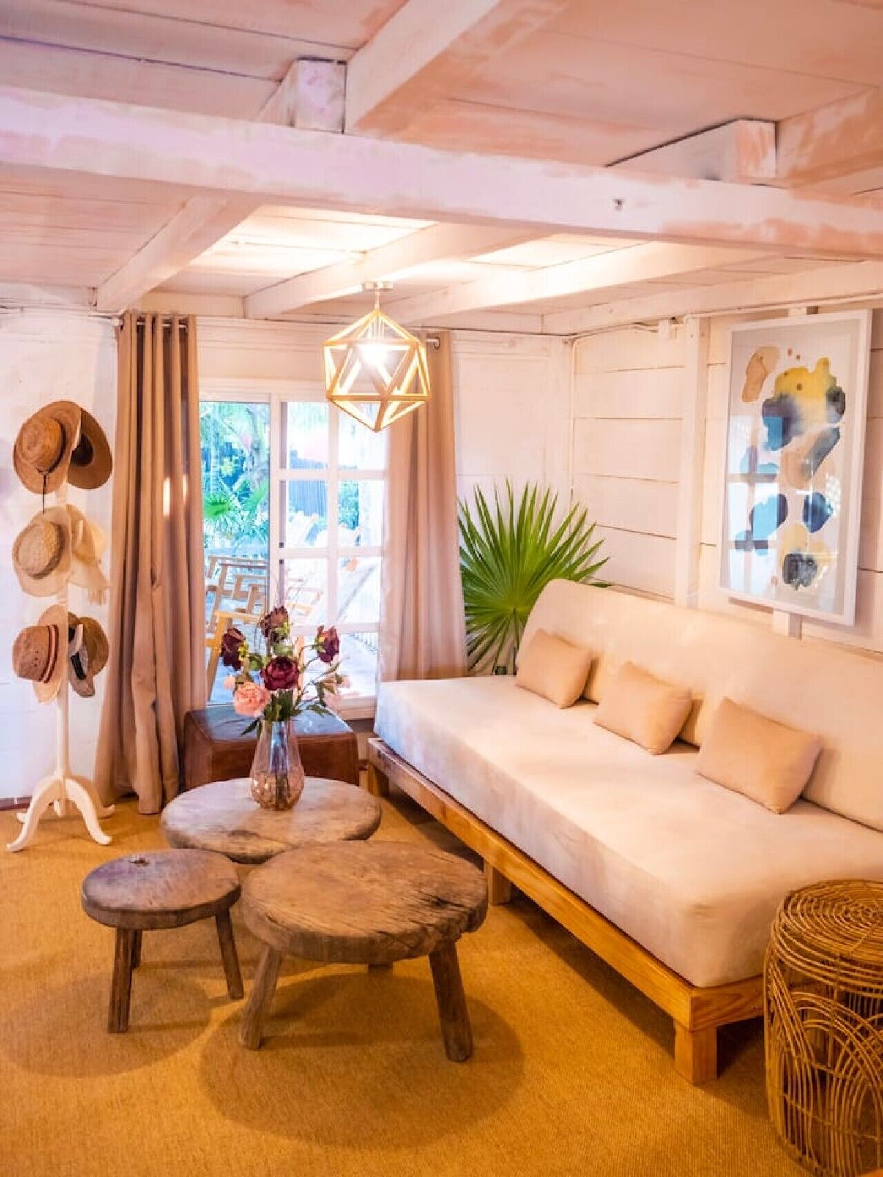 A cozy living room with a sofa, wooden coffee table, and a hanging light fixture.