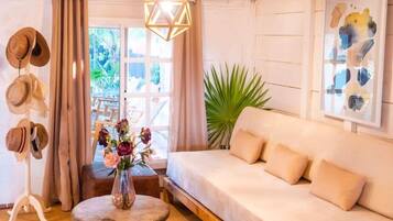 A cozy living room with a sofa, wooden coffee table, and a hanging light fixture.
