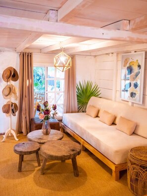 A cozy living room with a sofa, wooden coffee table, and a hanging light fixture.