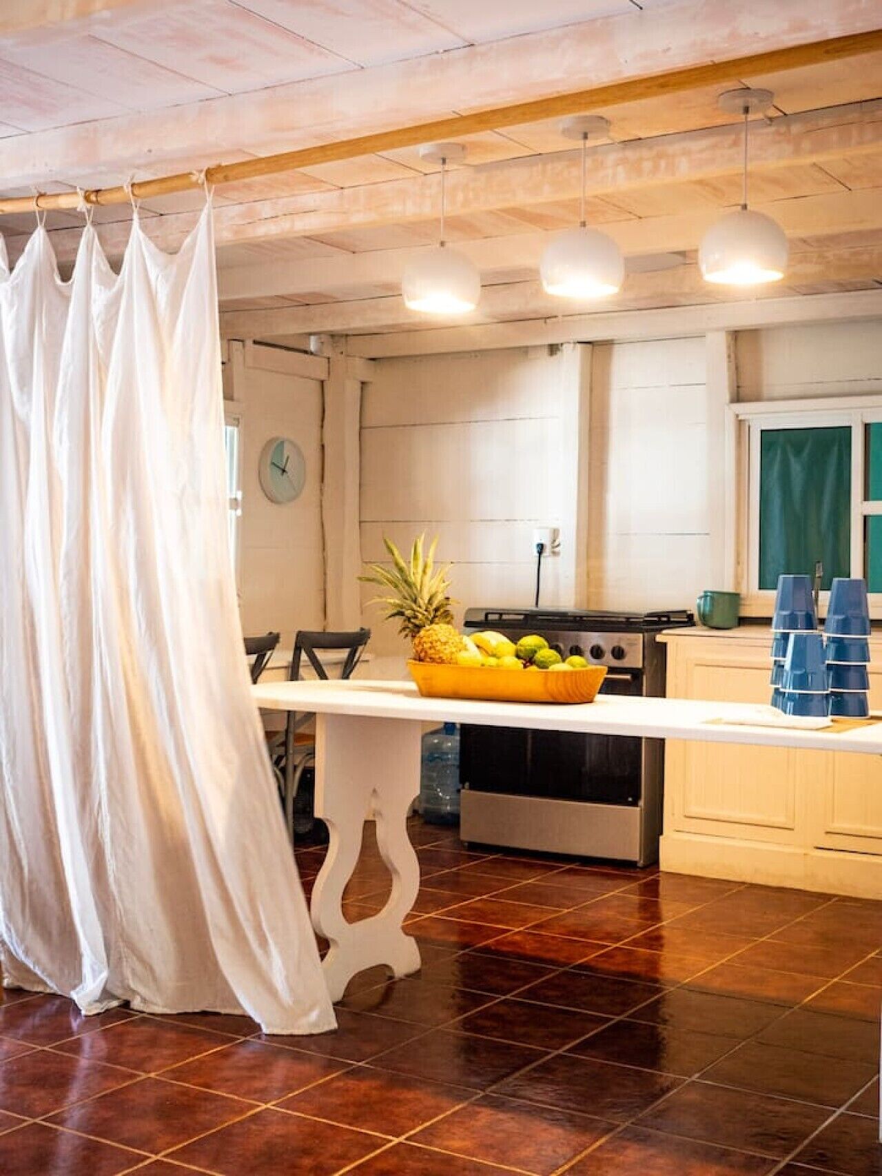 Una cocina con encimera blanca, frutero y estufa.