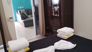 A hotel room with a bed, a wardrobe, and a sliding door leading to a living area. - Modern Beachside Retreat • Pool•Parking•Fast Wi-Fi (Playa Agua Blanca)