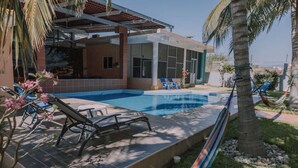 A modern house with a swimming pool, lounge chairs, and a hammock. - Modern Beachside Retreat • Pool•Parking•Fast Wi-Fi (Playa Agua Blanca)