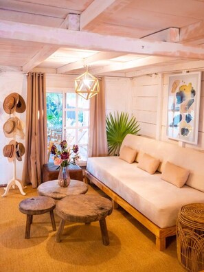 A cozy living room with a sofa, wooden coffee table, and a hanging light fixture.
