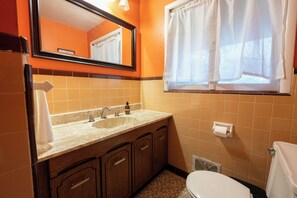 A bathroom with a sink, mirror, and toilet.