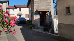 Un carrer estret amb un edifici de teulada inclinada i parets de pedra.