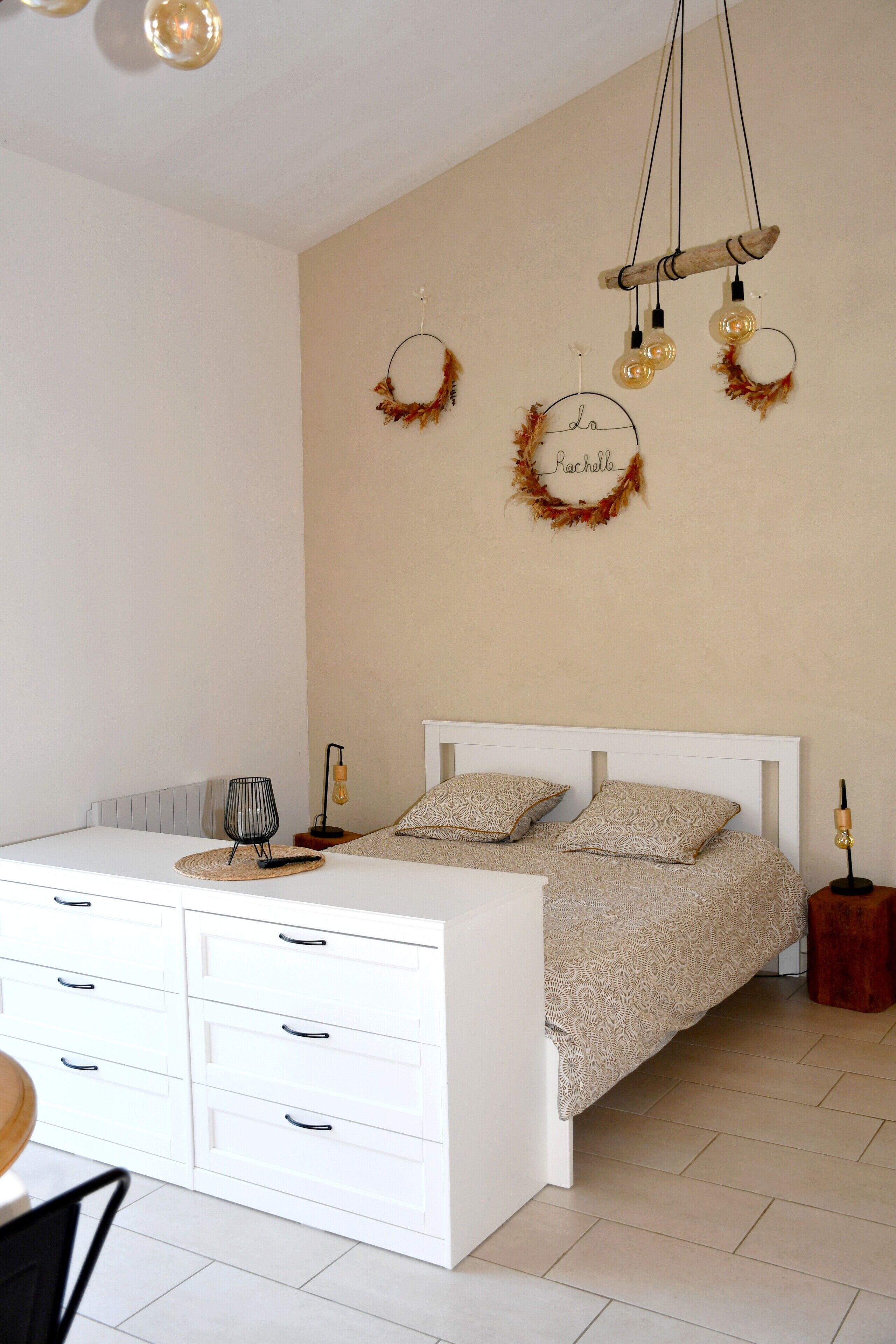 Un dormitorio con cama, mesitas de noche, un escritorio y una silla.