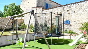 Un'area giochi con altalene, un trampolino e un canestro da basket.