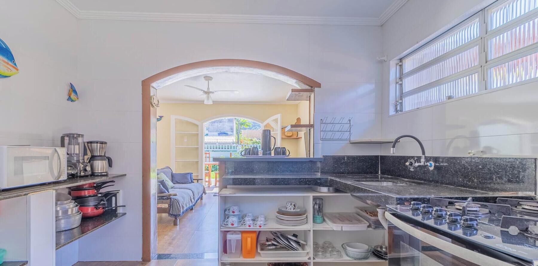 A kitchen with a stove, microwave, and various utensils.