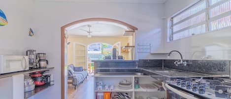 A kitchen with a stove, microwave, and various utensils.