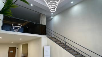 A modern interior with a staircase, a dining area, and a living space with a view.