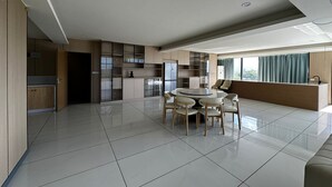 Un espacio habitable amplio con una mesa de comedor, sillas, cocina y un ventanal grande.