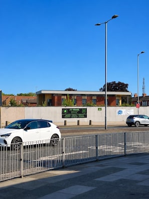 A building with a signboard advertising F.T. Travel, a parking area, and a street with cars. - NEW 1-BR apartment in Liverpool - Sleeps 4 - City Centre - Anfield & Everton (Liverpool)