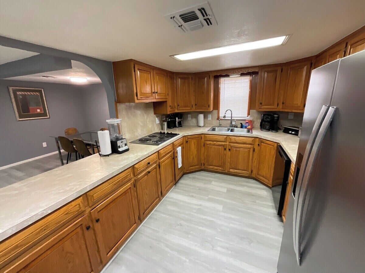 A kitchen with wooden cabinets, a stainless steel refrigerator, and a microwave.