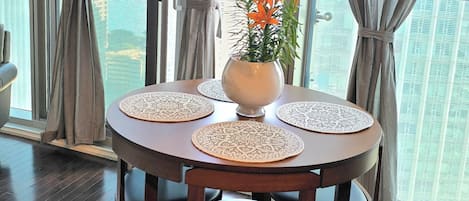 A dining area with a round table, chairs, and a vase with flowers.