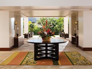 A hotel lobby with a round table, potted plants, and a view of greenery outside. - 2 Bedroom Villa at Marriott Kaua'i Lagoons (Lihue)