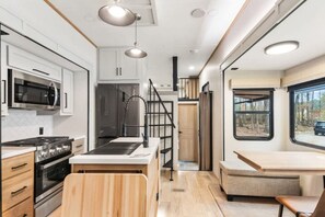 A compact kitchen with modern appliances, a wooden island, and a view through a window. - 12  bdrms/20 beds/pool/Hot Tub/3 RV`s/ATVs/30 acres (Ellenwood)