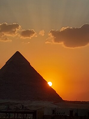 Eine Pyramide vor einem Sonnenuntergangshimmel.