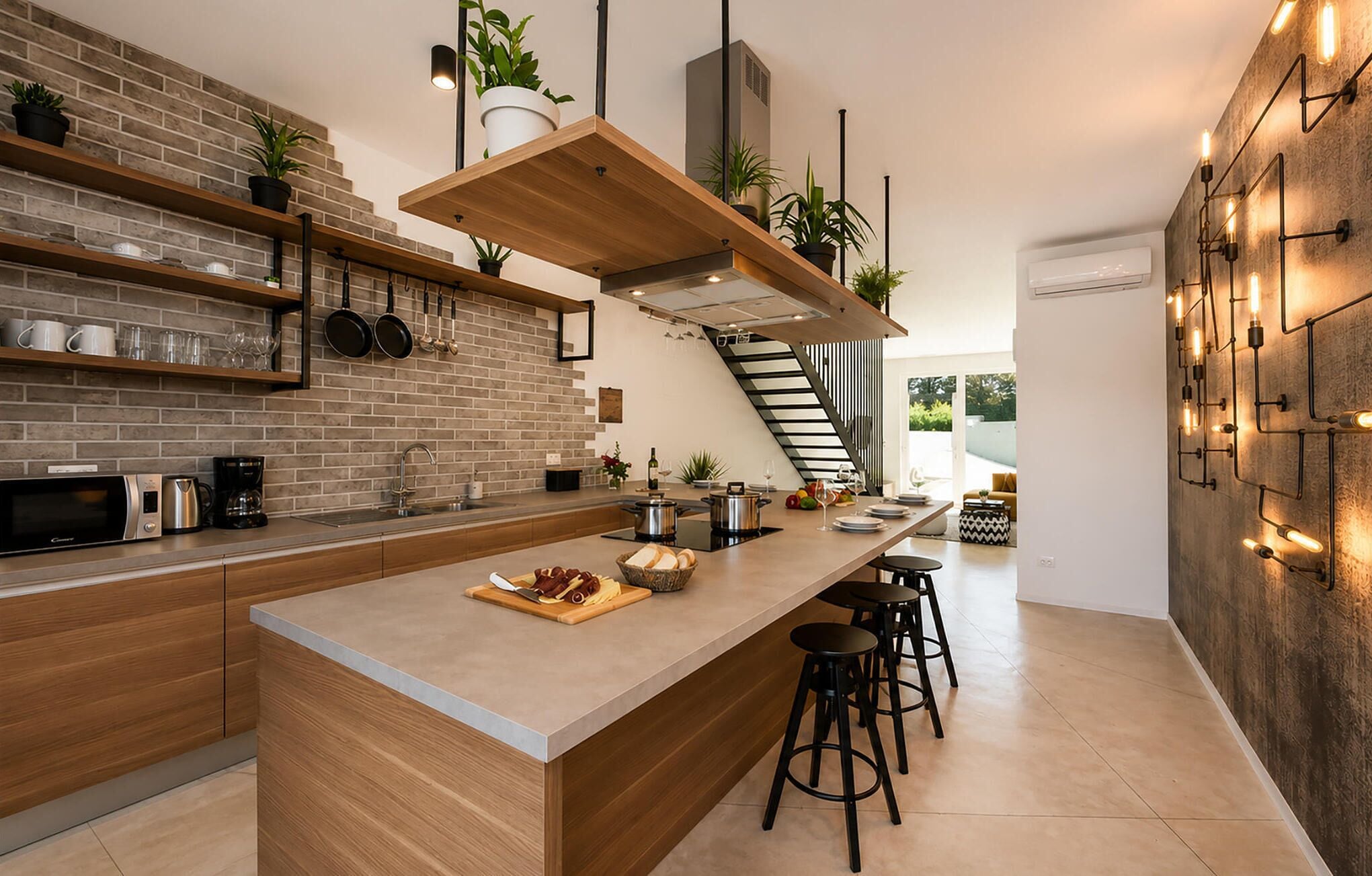 Eine moderne Küche mit Ziegelrückwand, Holzregalen und einer zentralen Kochinsel mit Hockern.