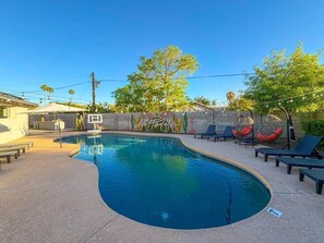 A swimming pool with lounge chairs and a basketball hoop. - Pool, Putts & Paradise | Modern Lux Golden Getaway (Scottsdale)