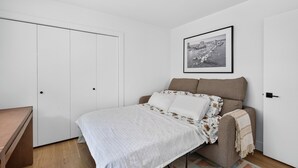 Ett sovrum med en säng, en soffa, ett skrivbord och en garderob.