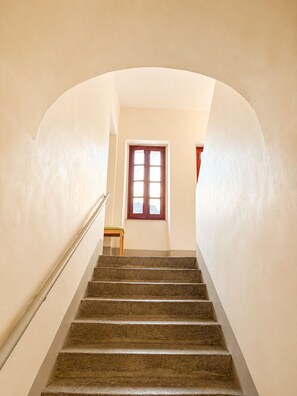 A staircase with a wooden handrail, leading to a room with a window and a small table. - Cozy Studio in the Heart of Nantes | Everything Within Walking Distance | Train Station 5 Minutes Away (Nantes)