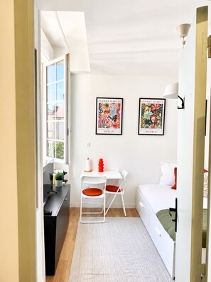 A compact room with a desk, two chairs, a bed, and two framed pictures on the wall. - Cozy Studio in the Heart of Nantes | Everything Within Walking Distance | Train Station 5 Minutes Away (Nantes)