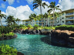 A resort with a clear pool, palm trees, and a multi-story building with balconies. - 3 Bedroom Villa at Marriott Kaua'i Lagoons (Lihue)