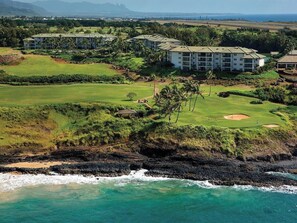 Un complejo turístico frente al mar con campo de golf y un edificio de varios pisos.