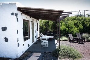 Une maison moderne dotée d’un patio, d’un espace salon extérieur et offrant une vue sur la verdure environnante.