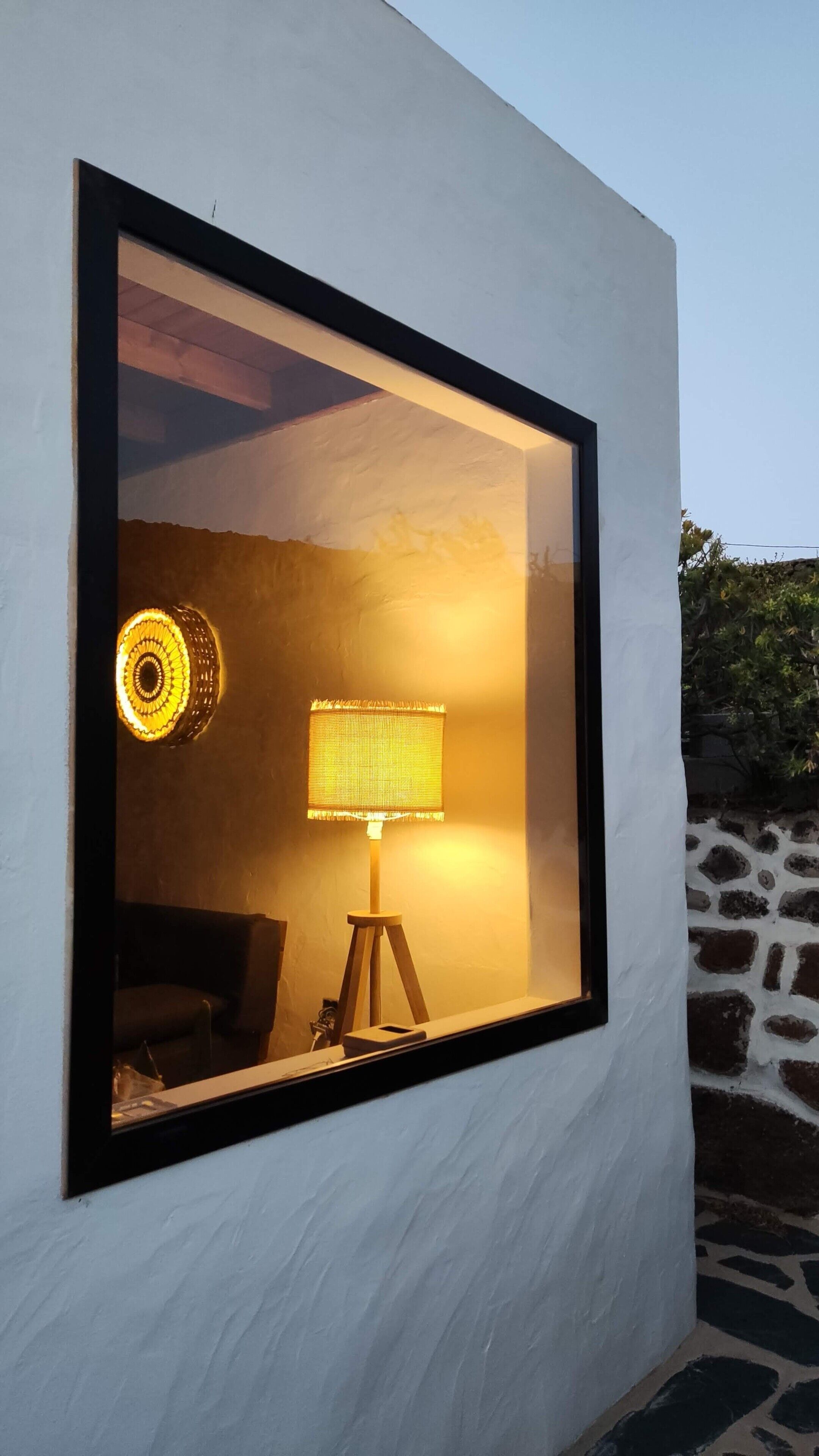Ein modernes Interieur mit einem großen Fenster, einer Lampe und einem Sofa.