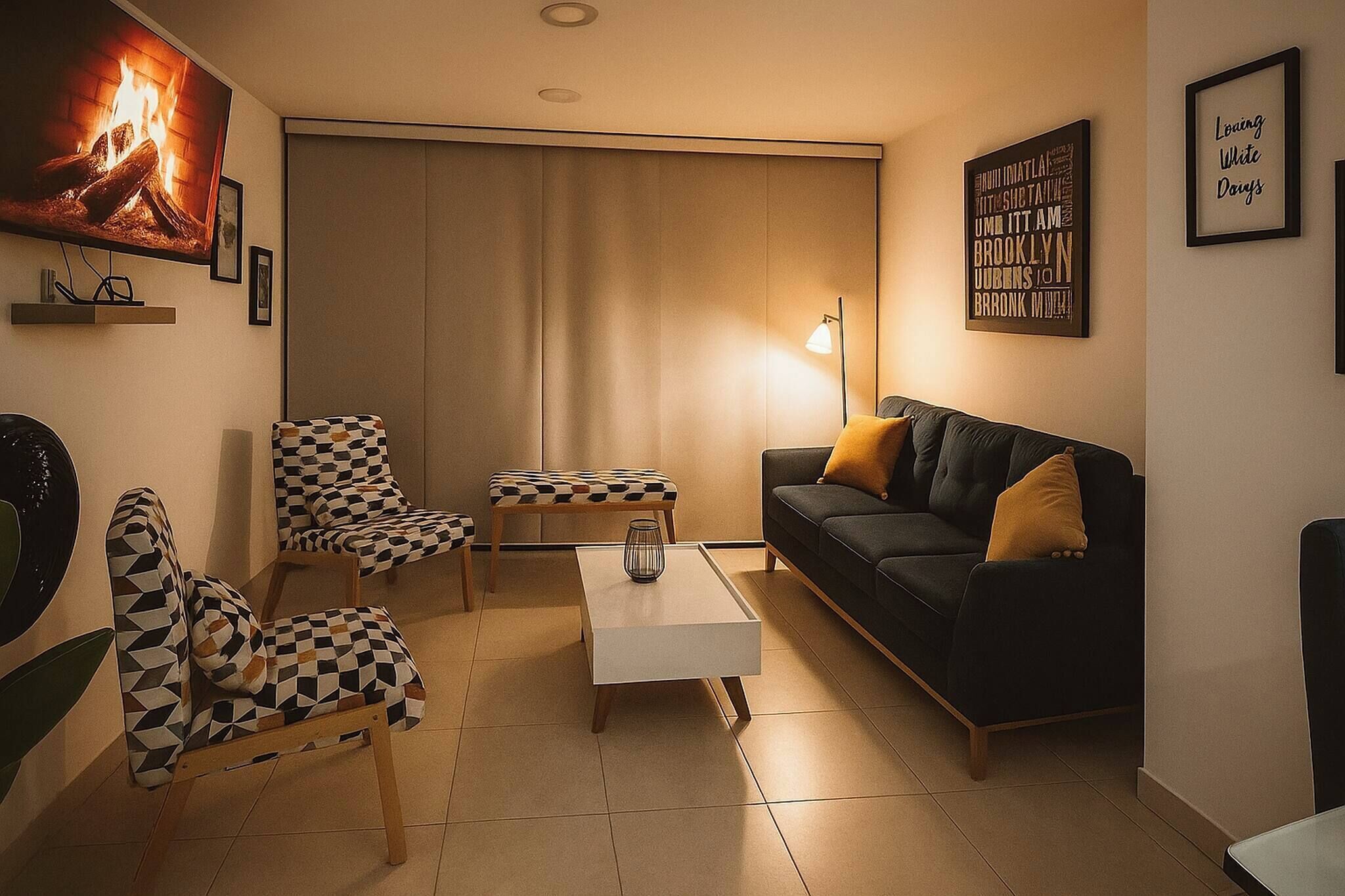 A living room with a sofa, armchairs, a coffee table, and a fireplace.
