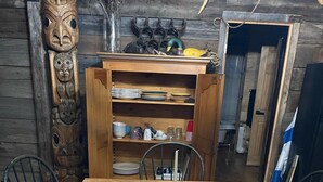 A wooden dining table with a green plate, a candle, and a white object on it. - Beautifully Private Chalet in Sainte Anne du Lac! Perfect lake! (Sainte Anne du Lac)