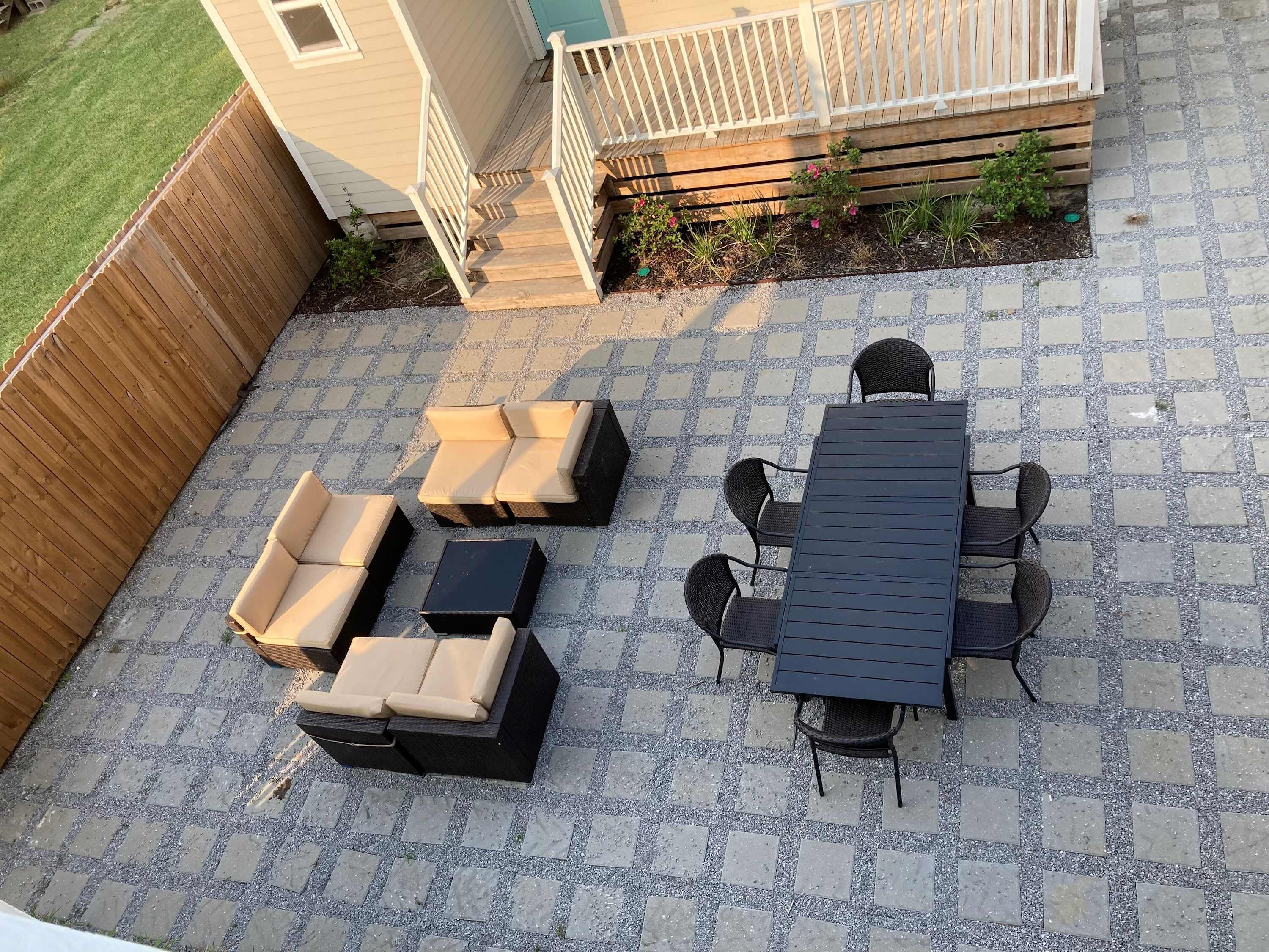 Une terrasse avec une table et des chaises, un canapé et un petit coin jardin.