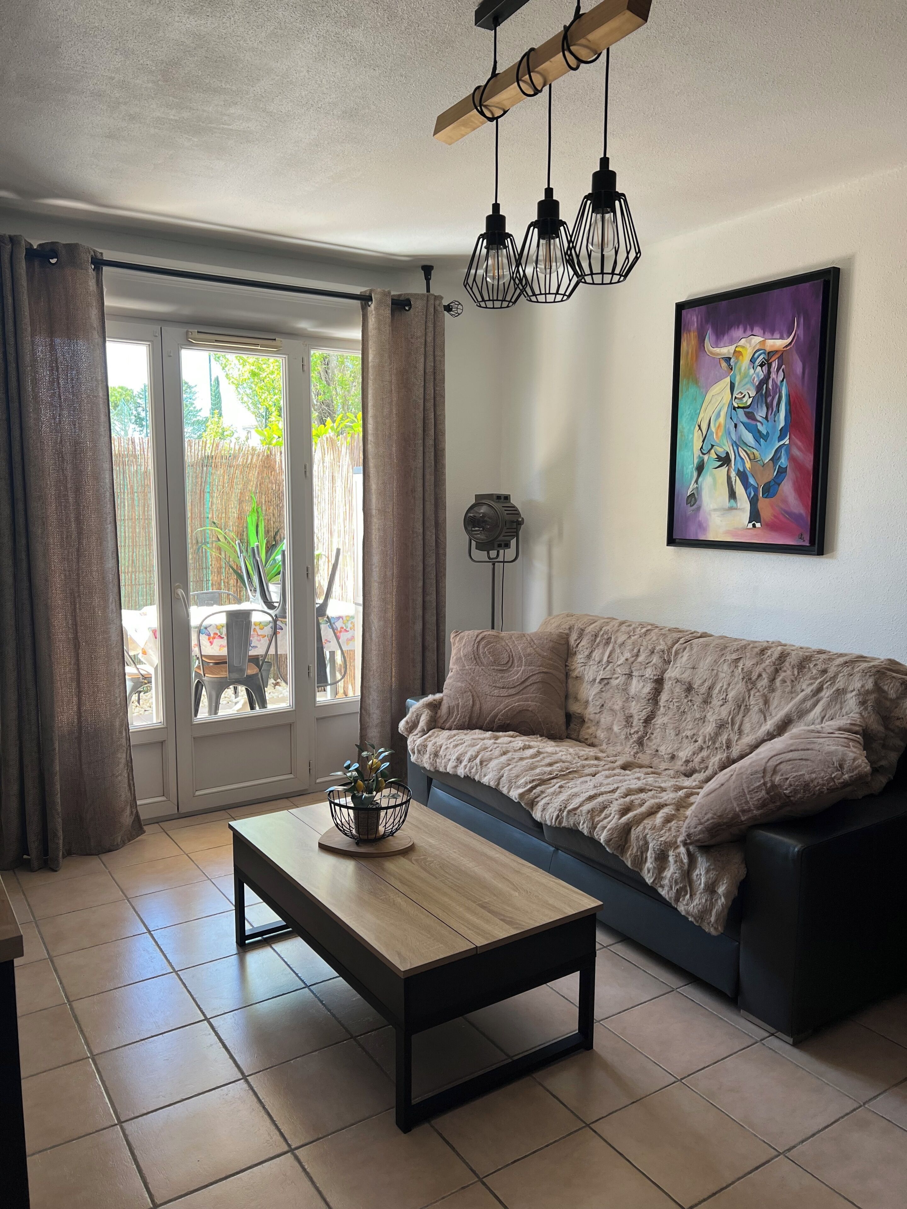 A living room with a sofa, a coffee table, a lamp, and a painting on the wall.