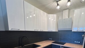 Ett modernt kök med diskmaskin, tvättmaskin och diskho.