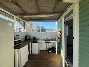 A compact kitchen with a wooden countertop, a sink, a toaster, and a kettle.